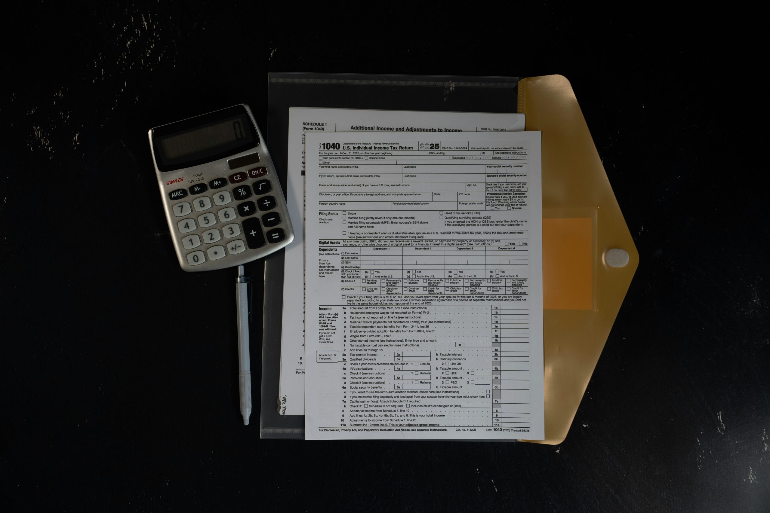 Financial documents, calculator and pen prepared for review
